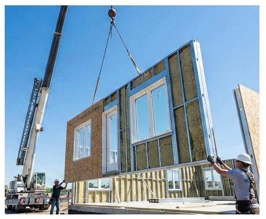Crane lifting a prefabricated wall panel into place